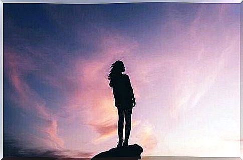 A woman on a rock at sunset