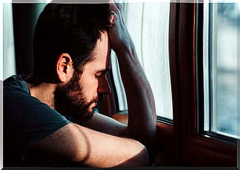 Pensive man in front of the window