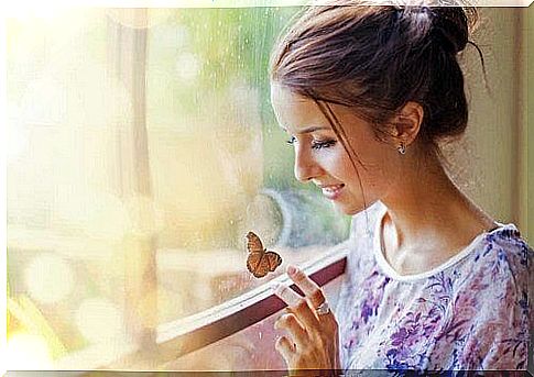 Woman at the window touches a butterfly.