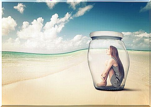 Woman closed in glass jar on the beach