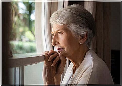 Elderly woman looking to the window