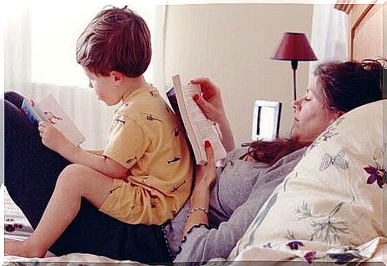 Mother with son on the bed reading