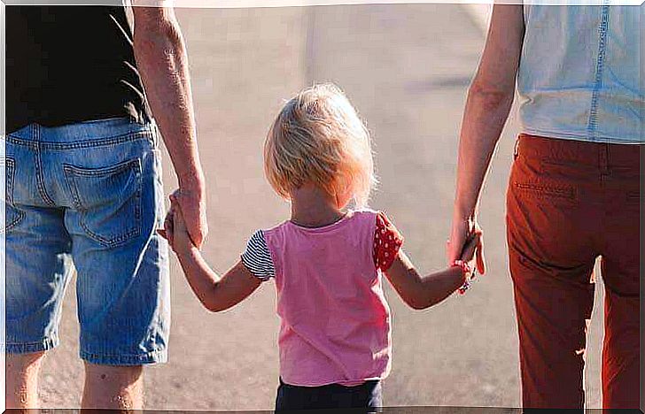 Parents hold daughter by the hand