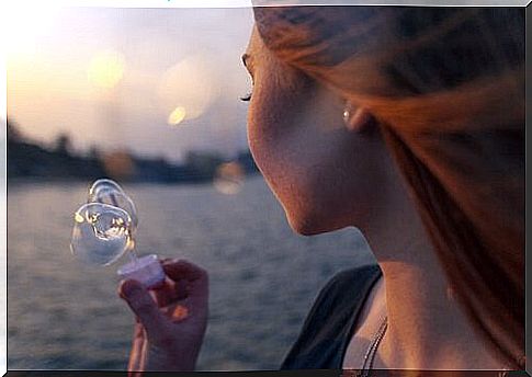 girl makes soap bubbles