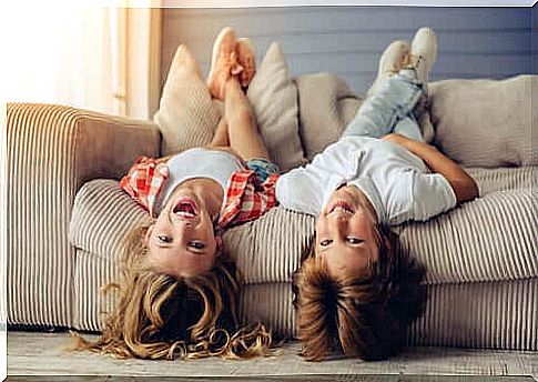 Children playing upside down on the sofa.