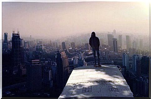 Boy on top of skyscrapers thinking about the fear of shining