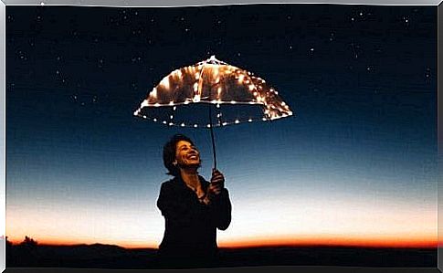 Woman with an umbrella illuminated by lights