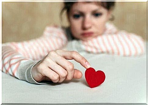 Worried woman playing with a heart.