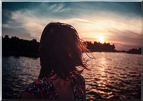 Woman thinking about the past while looking at the sea